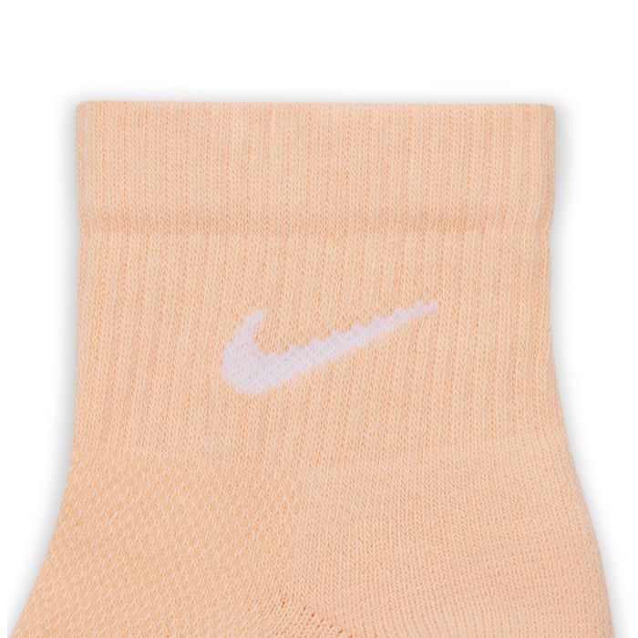 Peach quarter sock close-up with white Nike swoosh on knit cuff