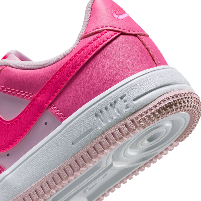Kids pink Nike sneaker close-up of midsole edge, embossed logo, and textured outsole