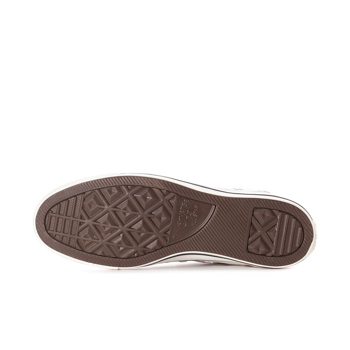 Outsole view of white high-top sneakers with brown rubber tread and traction pattern
