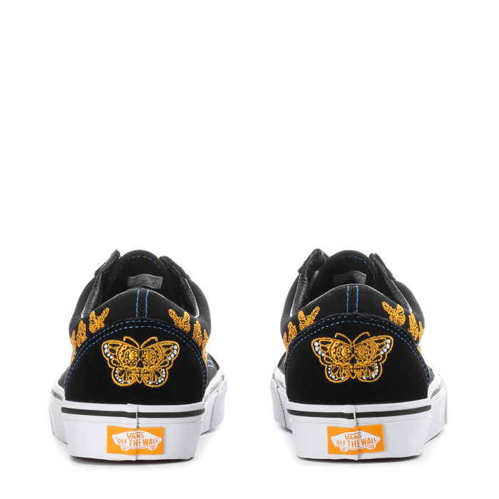 Women's sneakers back view, black with yellow butterfly embroidery, white rubber heel