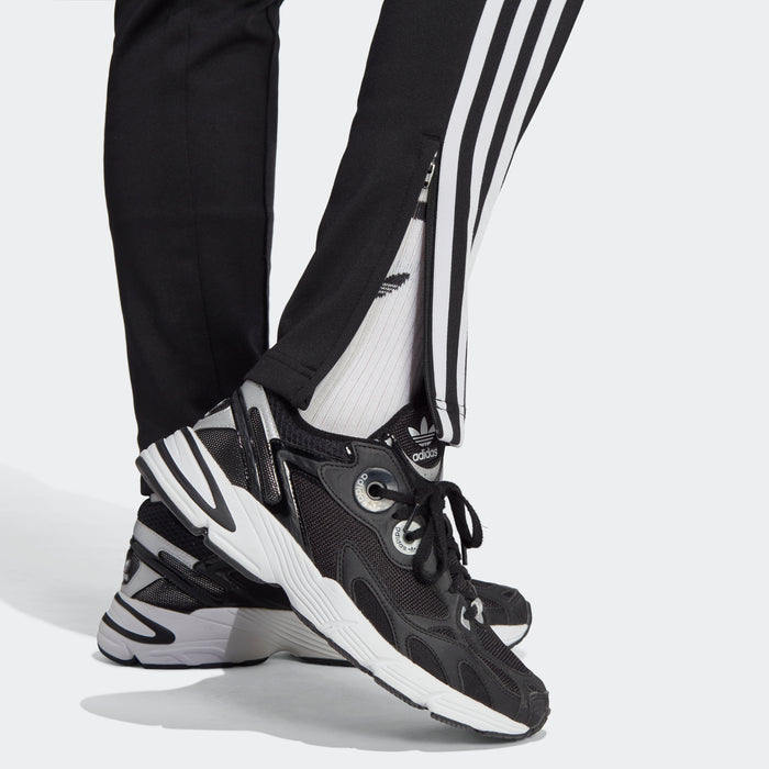 Women's black track pants with white triple stripes near hem, adidas logo