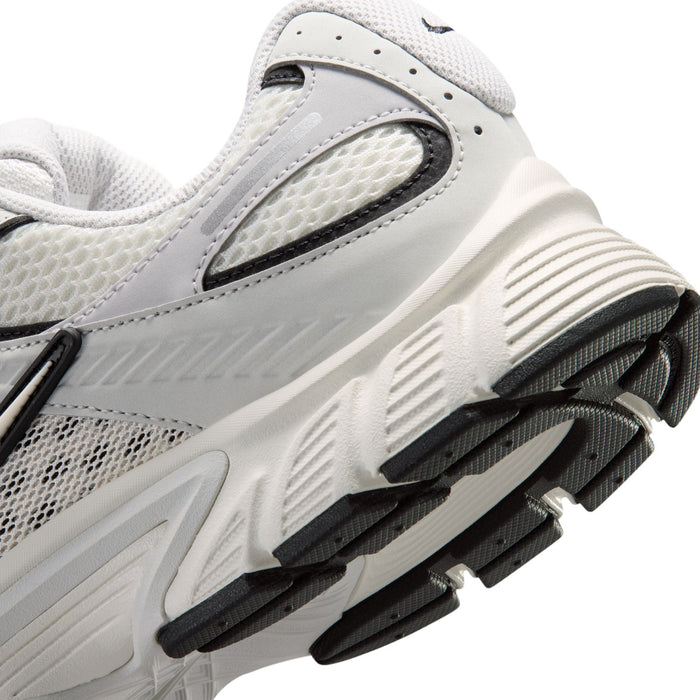 Men's running shoe side close-up with light gray upper and black-and-white tread