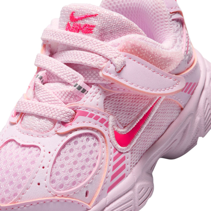 Toddler pink sneaker close-up with laces, stitching, and small swoosh logo