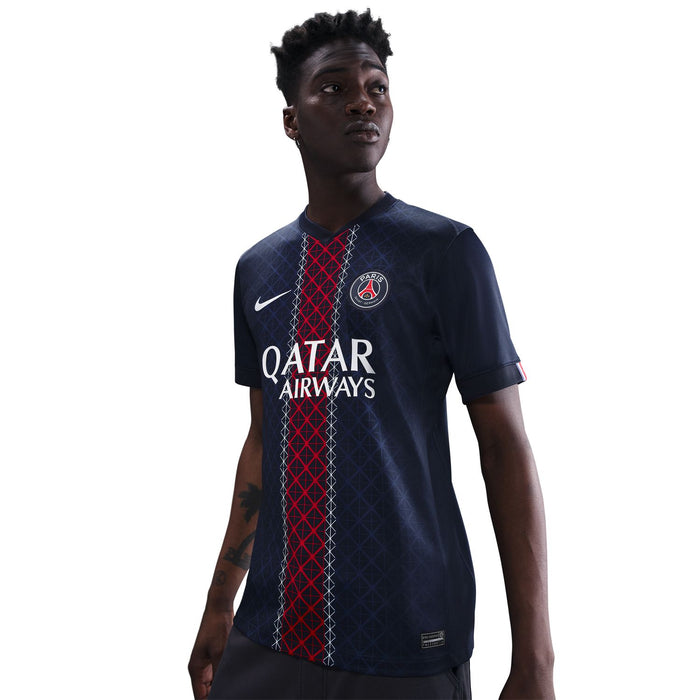 Men's PSG stadium home jersey on model, navy with QATAR AIRWAYS and red vertical design