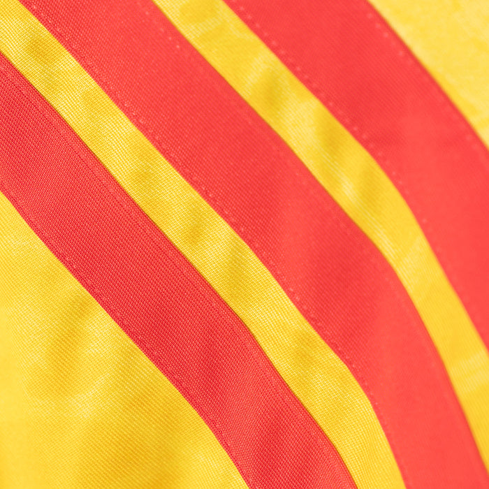 Close-up of yellow jersey fabric with diagonal red and yellow stripe detail