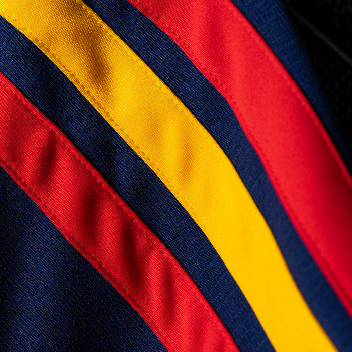 Red jersey fabric detail with yellow and navy diagonal stripes