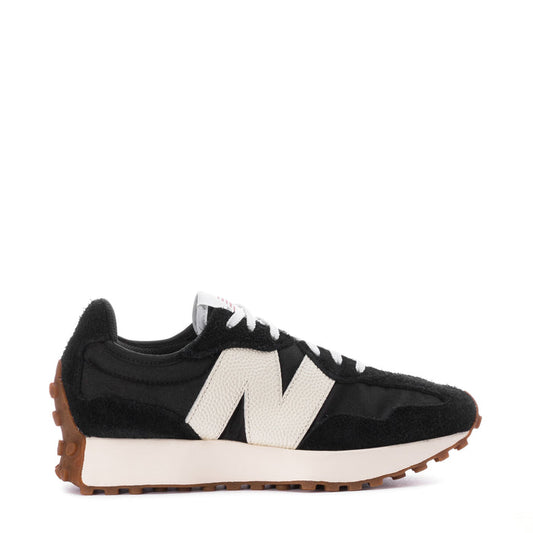 Women's black-and-white sneaker with white N logo, black laces, and gum rubber sole.
