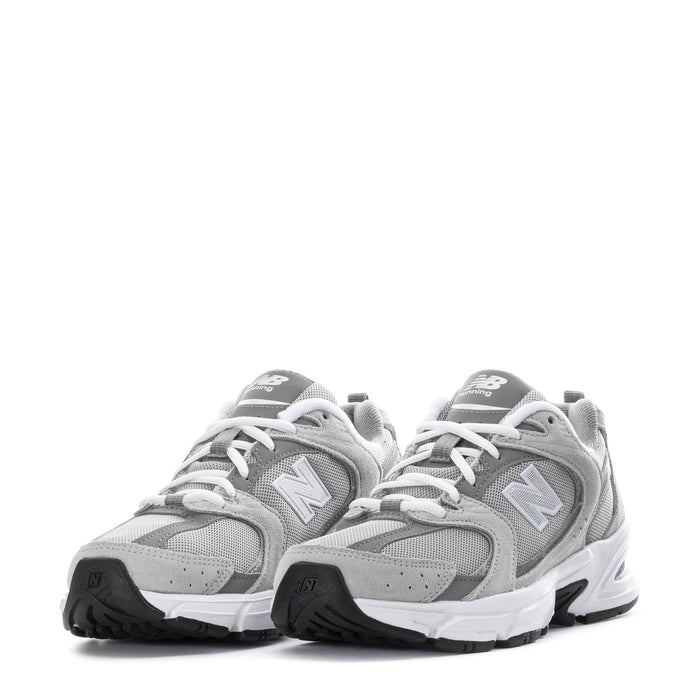 Pair of women's wide gray New Balance 530 sneakers with white laces and N logos