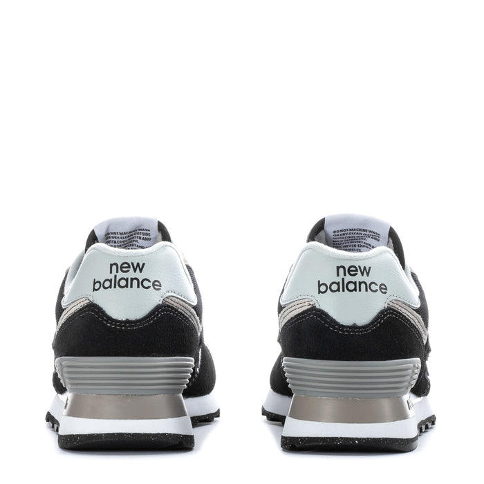 Women's black and white New Balance 574 sneakers, back view with "new balance" heel