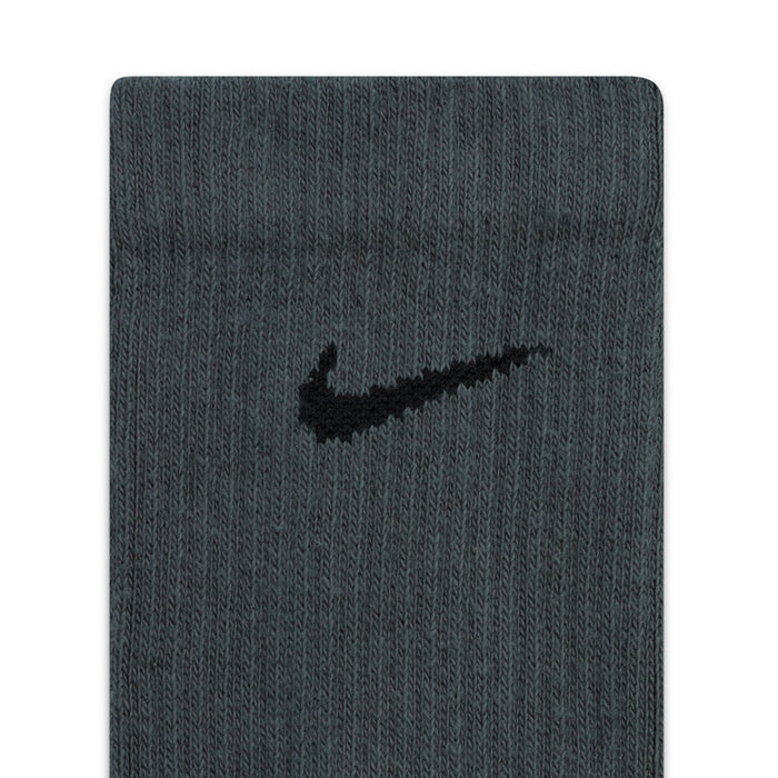 Dark gray crew sock fabric close-up with small swoosh-style logo on cuff