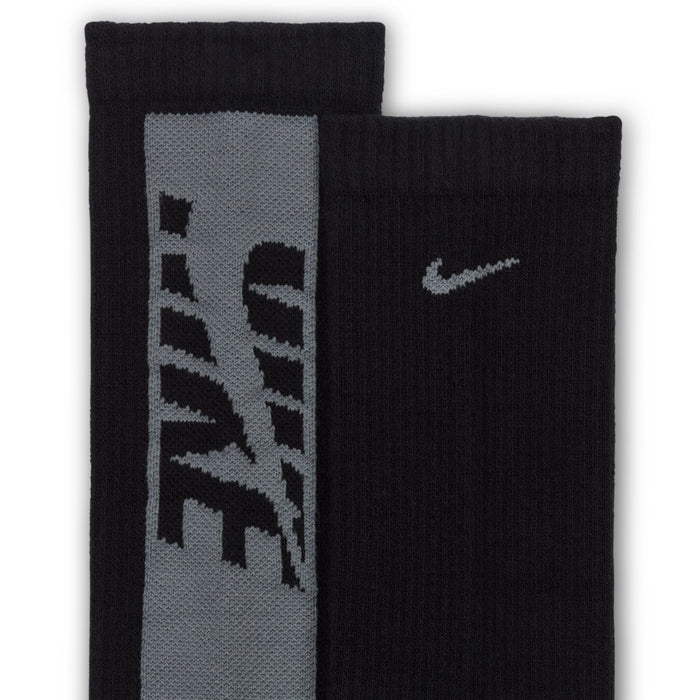 Youth crew socks close-up in black and gray with large graphic panels and a swoosh