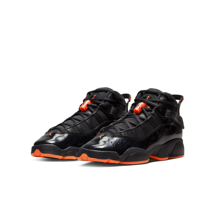 Youth black high-top sneakers with orange-red lace accents and chunky orange outsole