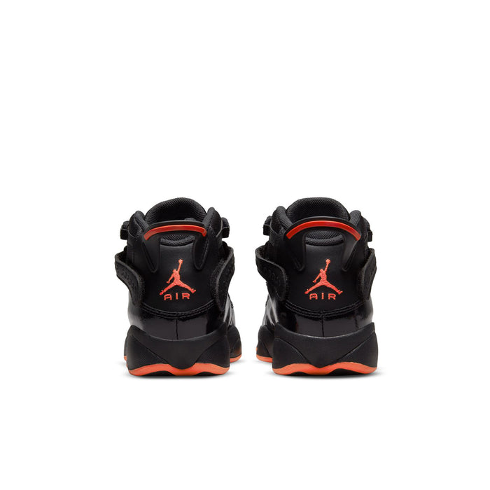 Youth black high-top sneakers showing rear heel with Jumpman logo and orange outsole