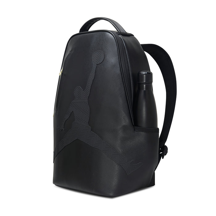 Black backpack with side pocket and attached water bottle, gold zipper detail