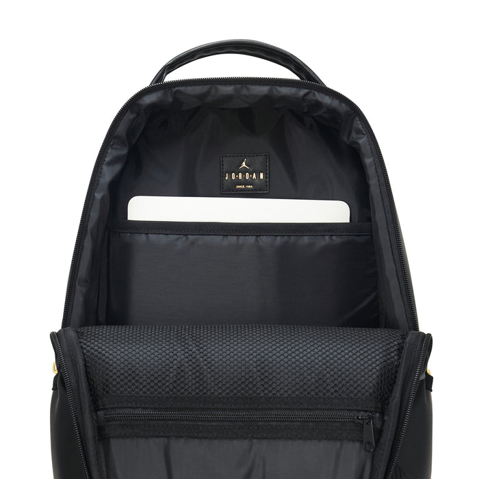 Black backpack interior with top handle, zip pocket, and white label patch