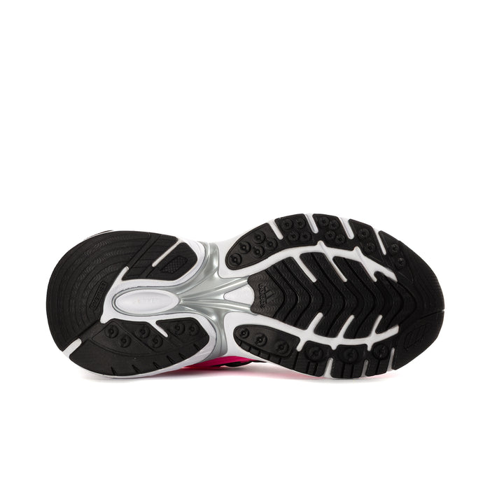 Women's sneaker outsole view, black traction tread with white midsole and hot pink detail