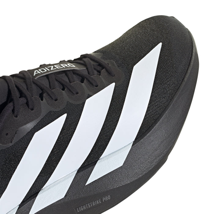 Close-up of black textile upper with three white stripes and stitched trim near the toe