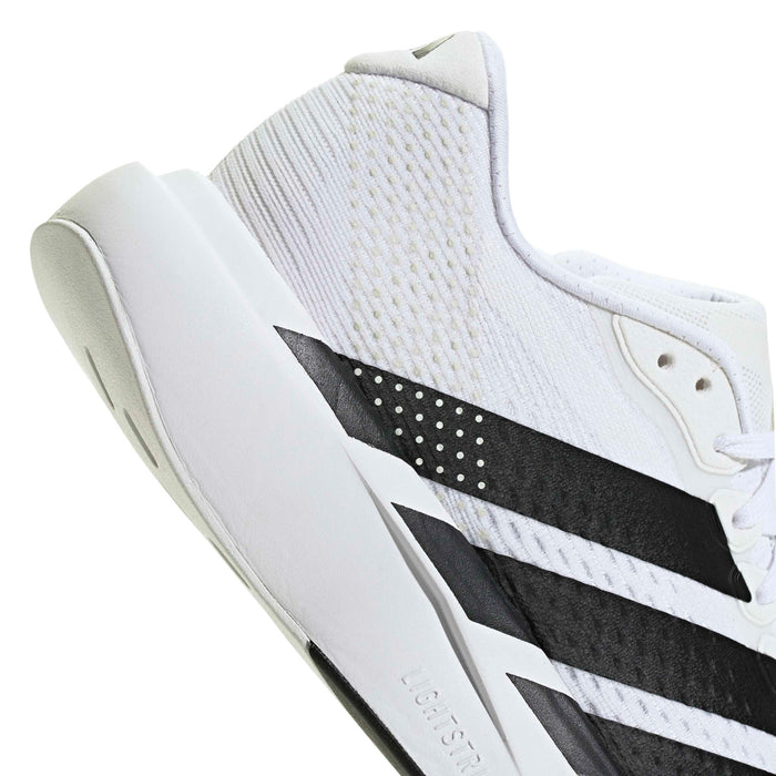 Women’s running shoes, close-up side profile with black stripe and dotted texture