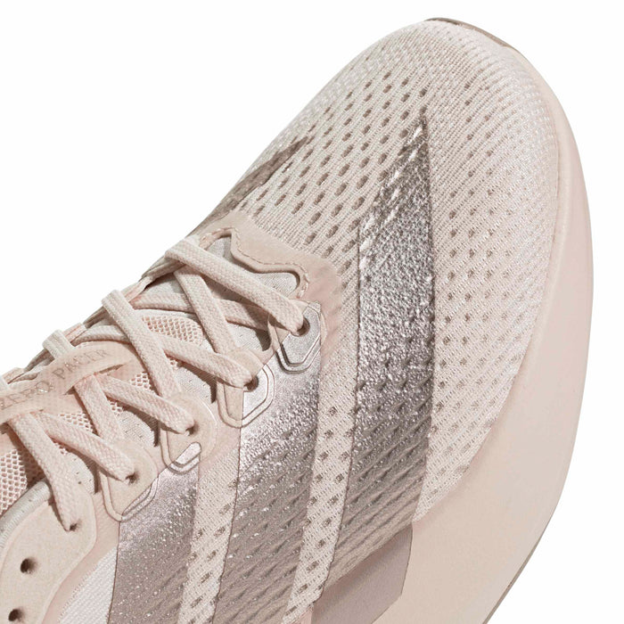 Women’s light pink knit running shoe upper detail with lace eyelets and side stripes.