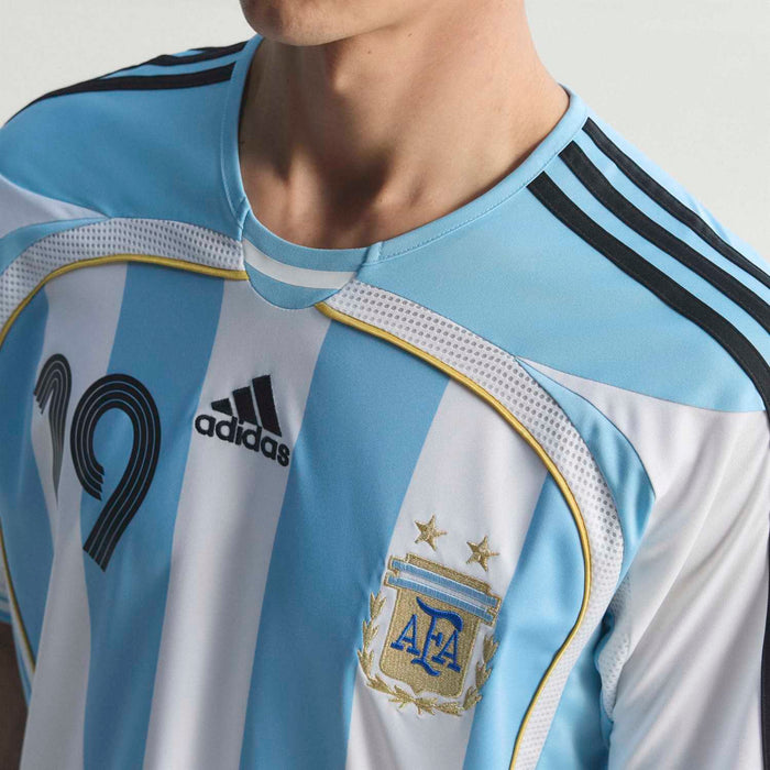 Men's striped football jersey close-up: adidas logo, black shoulder stripes, light blue trim