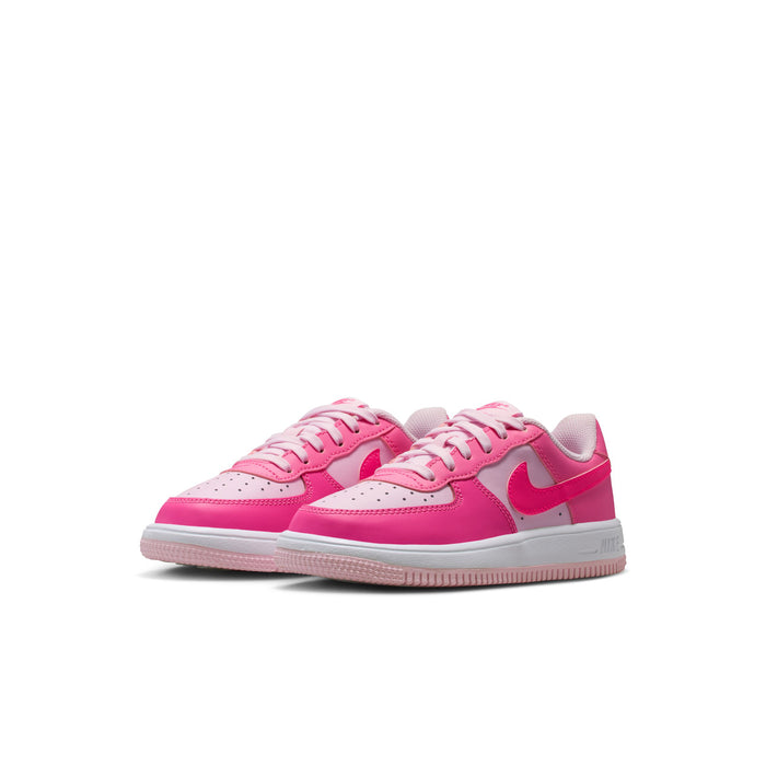 Kids pink and white Nike lace-up sneakers, side view with Swoosh and perforated toe
