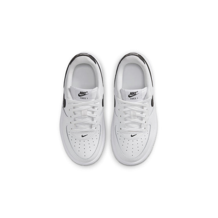 Kids' white sneakers with perforated toe and laces, top view of pair