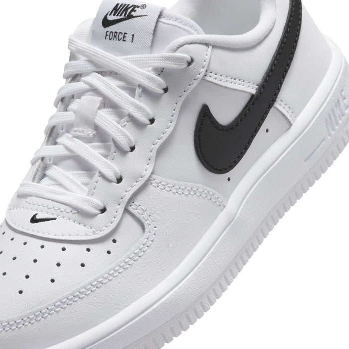 Kids' white sneaker upper with Nike swoosh, lace-up close-up