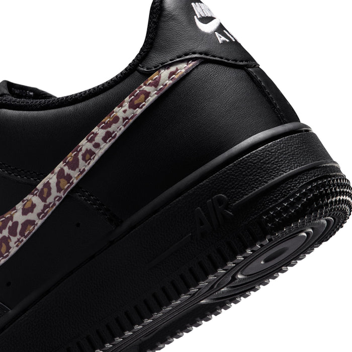 Close-up of black youth sneaker showing Nike Air midsole and leopard-print strap