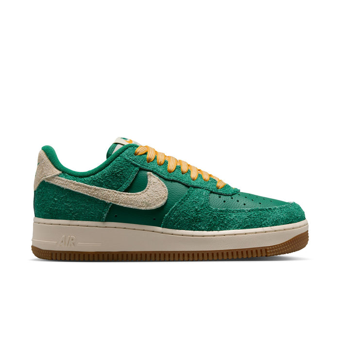 Women’s green suede low-top sneakers with beige Swoosh and yellow-orange laces