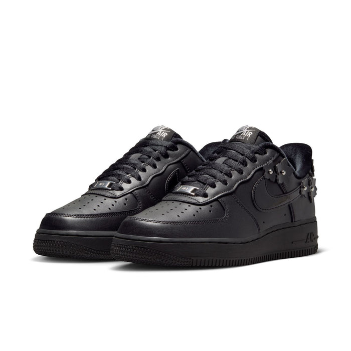 Women's black low-top sneakers, side-by-side view, Nike swoosh and studded charms