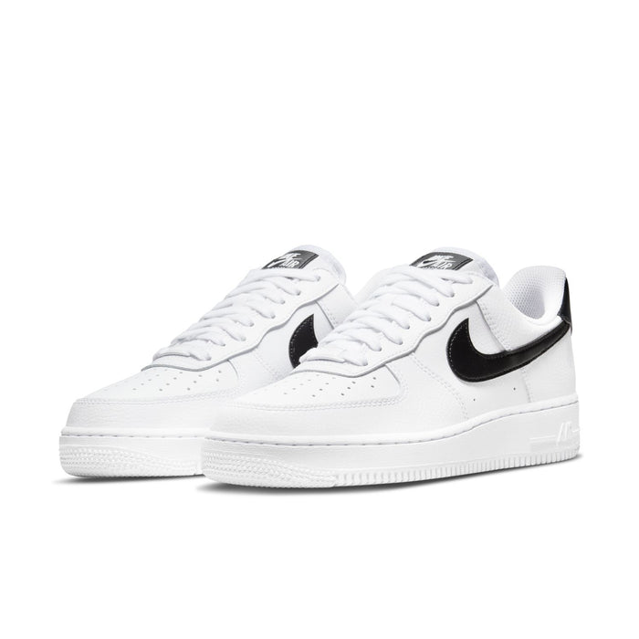 Pair of women’s white low-top sneakers with black Nike Swoosh and white laces