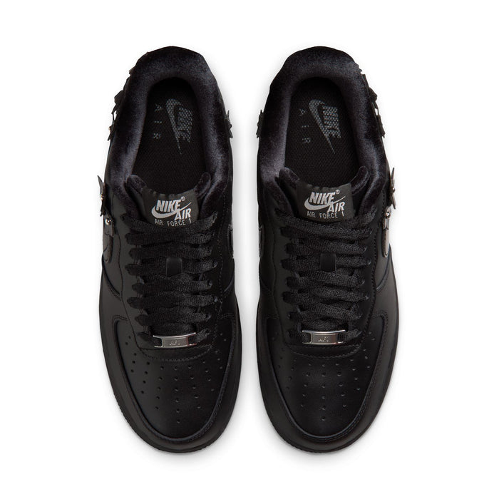 Pair of women's black low-top sneakers, top view with lace-up and perforated toe