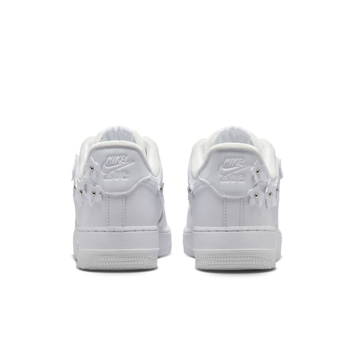 Back view of white Nike Air Force 1 sneakers with heel tab and lace-up collar