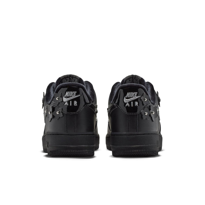 Women's black low-top sneakers, heel view with rear Nike Air branding and charms