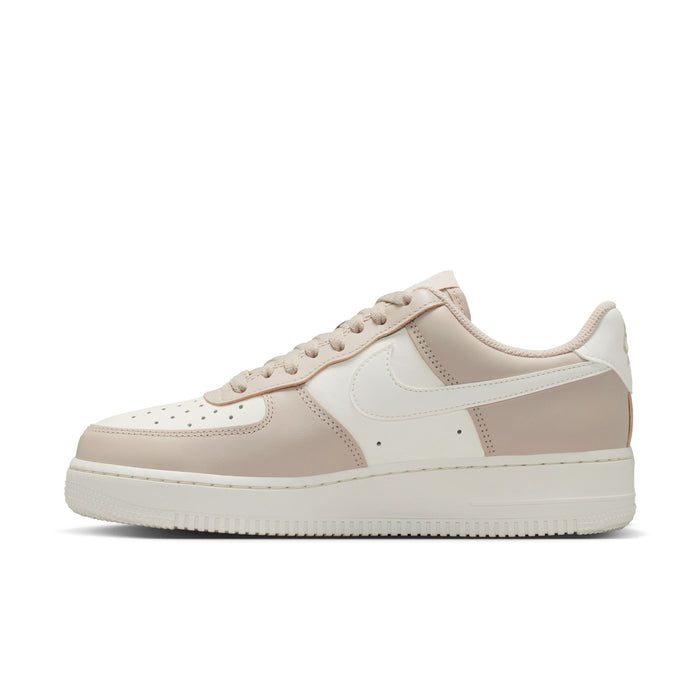 Cream and light tan low-top sneaker with lace-up, side panels, and gold detailing