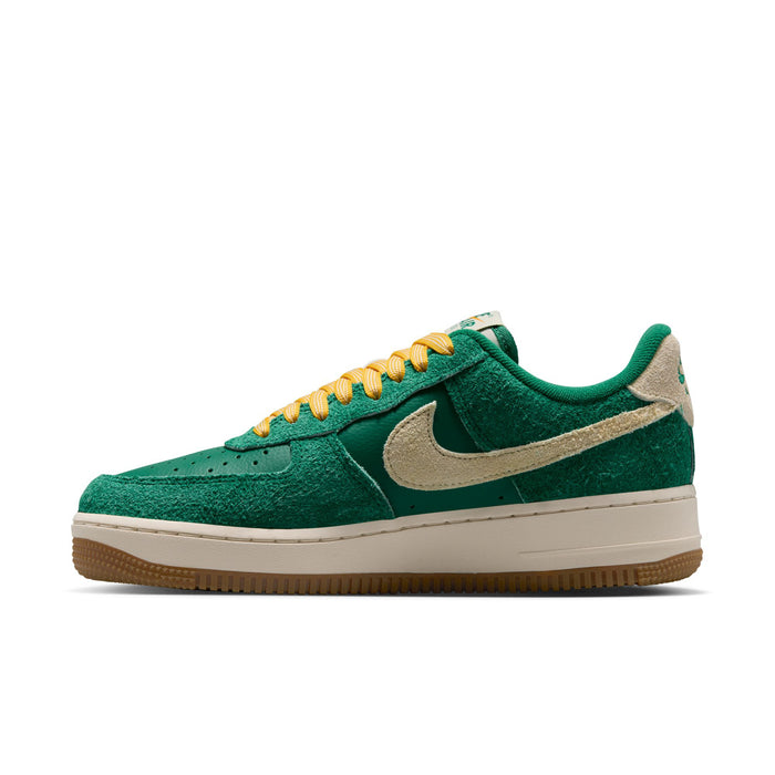 Green suede low-top sneakers with beige Swoosh, yellow-orange lace up, gum outsole