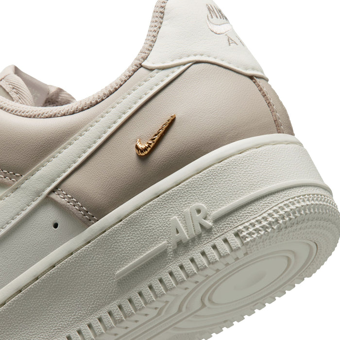 Close-up of sneaker side with gold Swoosh, Nike Air on sole, and padded lining