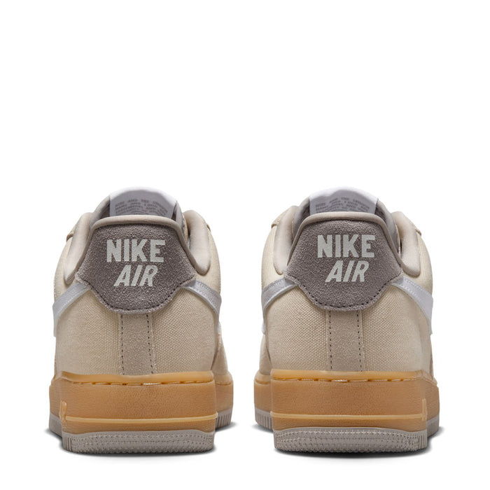 Nike Air Force 1 sneakers heel view, light khaki upper with Nike Air heel logo.