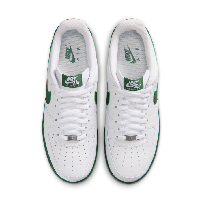 Men's white sneakers showing tongue and lace eyelets with green Air and Nike text.