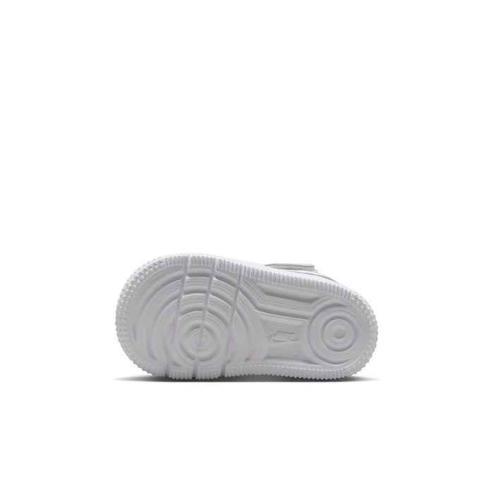 Toddler sneaker outsole view with tread pattern under white low-top sneakers