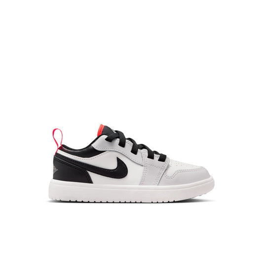 Kids low-top sneakers in white with black overlays and red lace accents