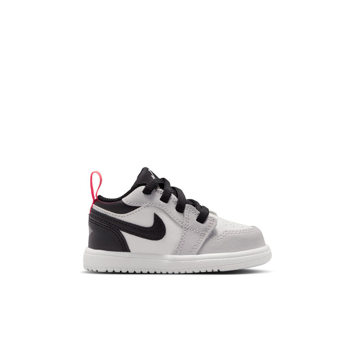 Kids low-top sneakers in white and black with black laces and red accents
