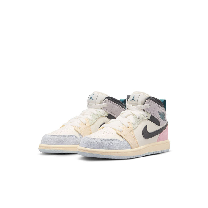 Kids Air Jordan 1 mid-top sneakers, cream uppers with black swoosh and pink hits.