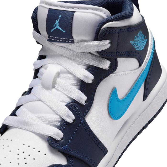 Kids sneaker close-up: white laces over navy-and-white panels with light blue swoosh