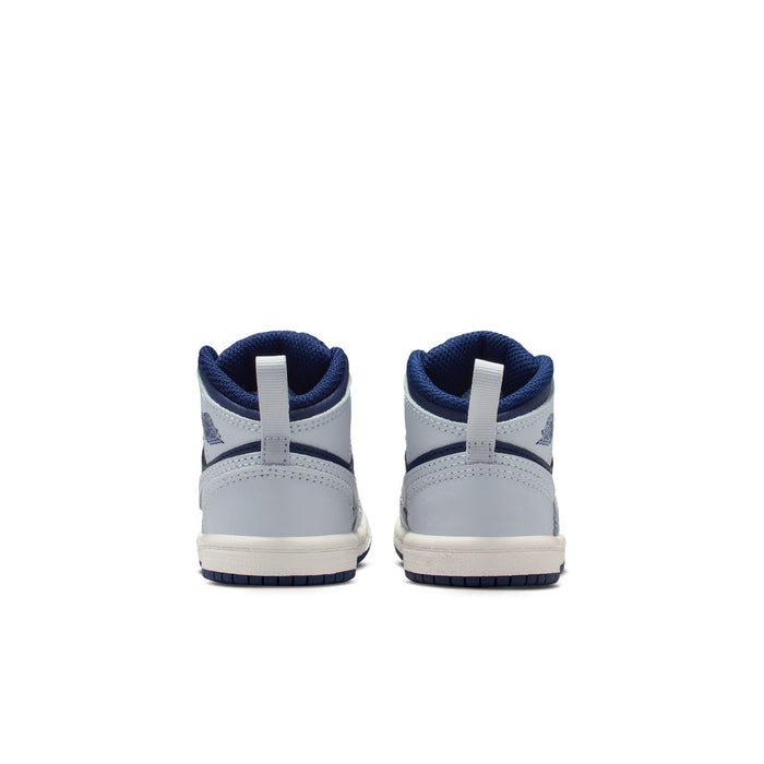 Toddler sneakers heel view with navy collar, white leather panels, and blue outsole edge