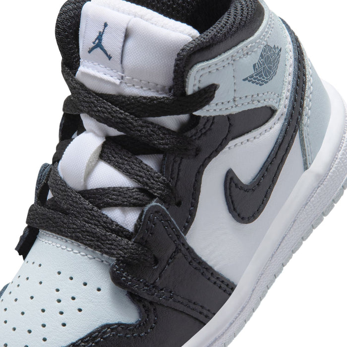 Toddler shoe upper close-up with black laces, white panels, and gray wing logo