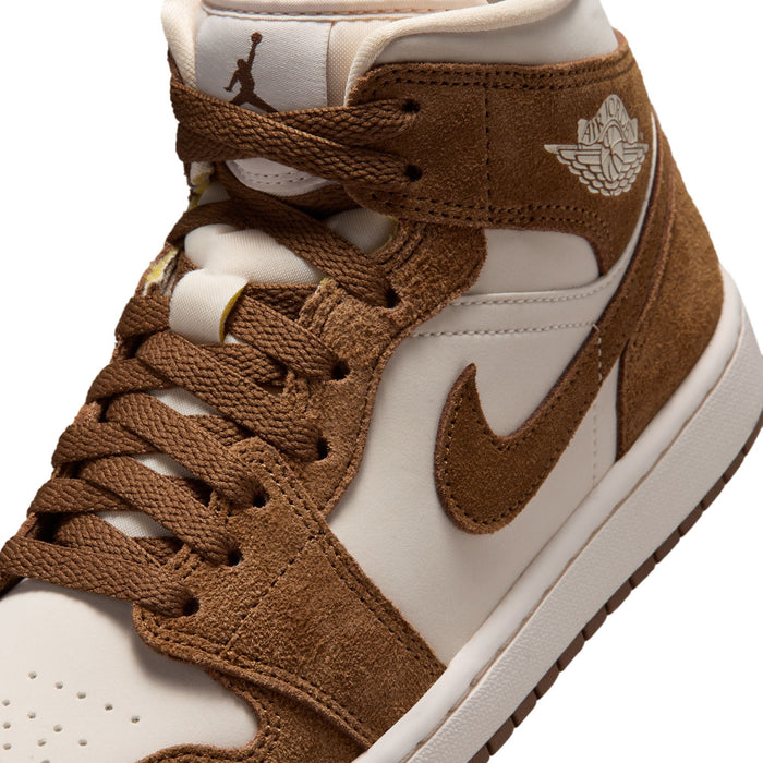 Close-up of women's mid-top sneakers with brown laces, white overlays, Air Jordan wings