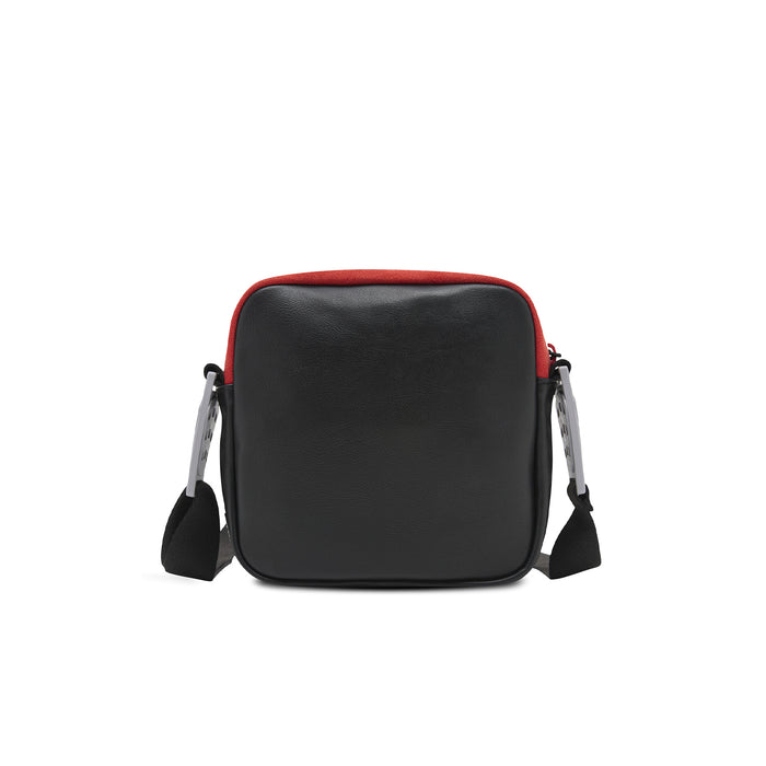 Black crossbody bag with red top trim, dual side handles, and zipper closure
