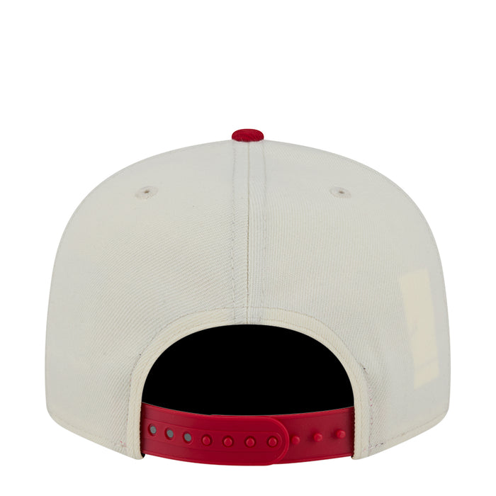 Two-tone baseball cap with white crown and red snapback strap, open back