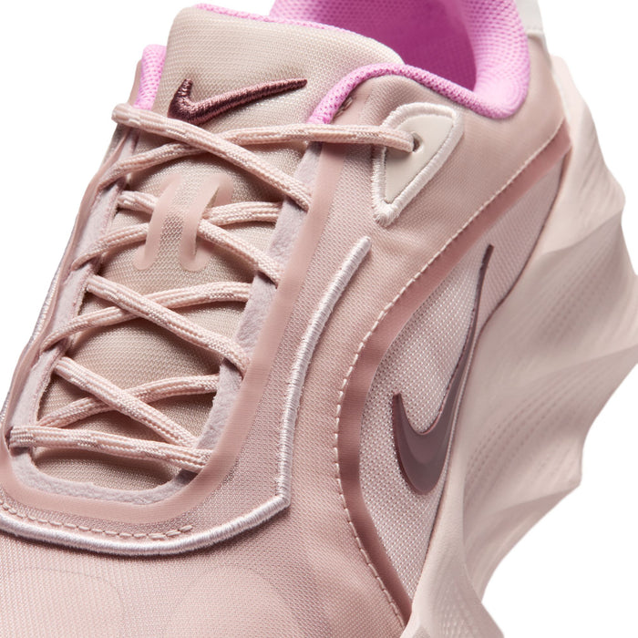 Close-up of light pink lace-up upper with stitched overlays and Nike swoosh